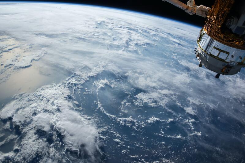 Image of the Earth taken from space with a satellite in the corner