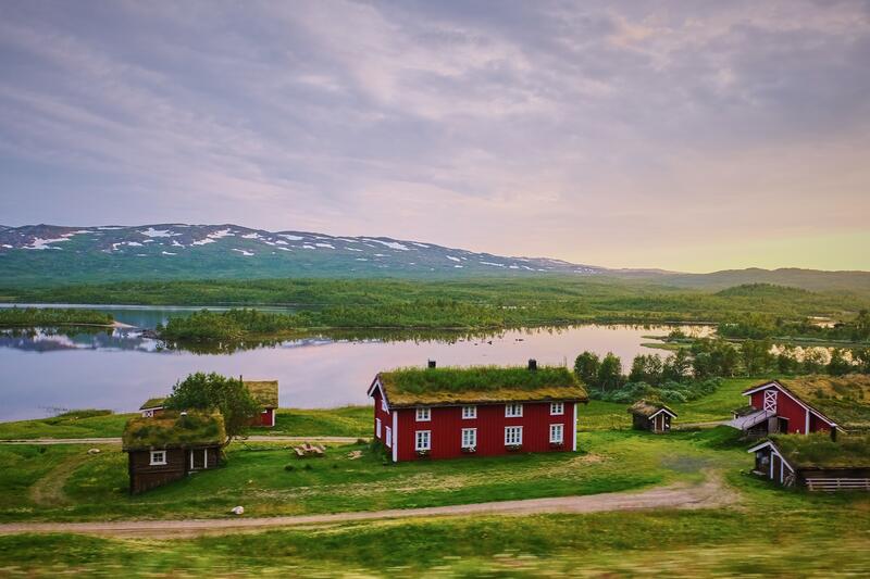 Landscape image of a lake and red Swedish houses