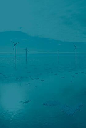 frozen sea with wind turbines in the background