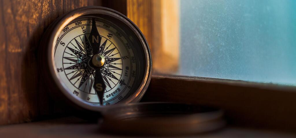 vintage compass standing on a windowsil