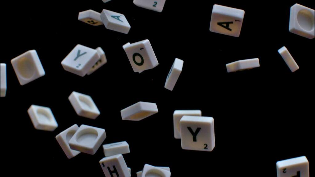 Scrabble tiles cascading from above against a dark background